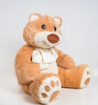 Teddy bear with a bow on a white background. Soft children's toy. Stock Photos
