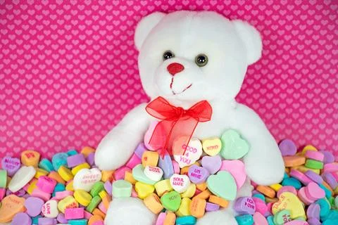 Teddy bear in candy hearts Stock Photos