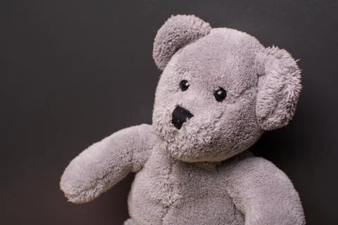 Teddy bear on a dark background, looking sad Stock Photos