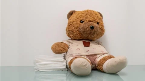 Teddy Bear With Diapers: Soft Plush Toy Surrounded by Stacked Diapers Stock Footage 322096620