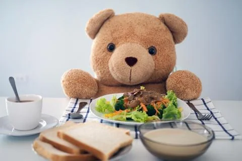 Teddy bear eating breakfast at the table in the house Foto stock