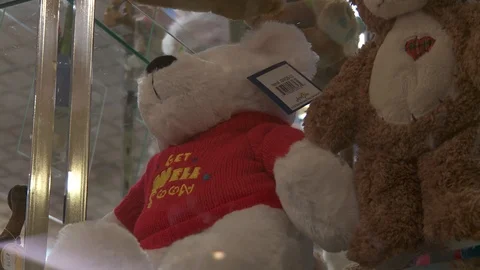 Teddy bear with Get Well Soon sweater, interior hospital. Vídeo Stock 111343742