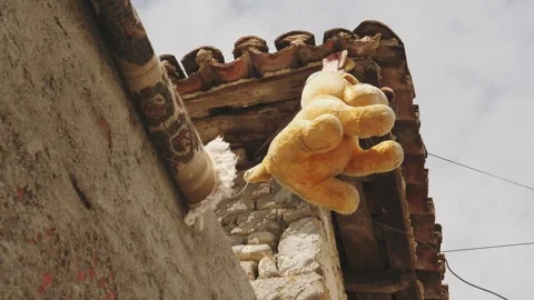 Teddy bear hanging in front of house in Albania To Keep Evil Eye or Spirit Away Stock Footage 255108727