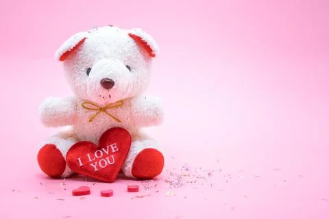 Teddy bear with "I Love You" heart on pink background. Love and Valentine con Stock Photos