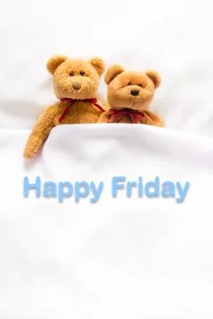 Teddy Bear lying in the white bed with message " Happy Friday"  Stock Photos