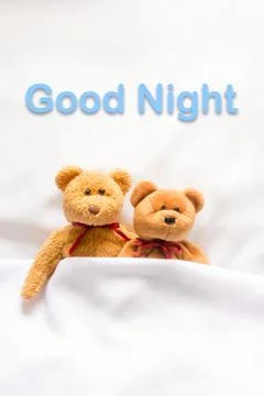 Teddy Bear lying in the white bed with message "Good night " Stock Photos