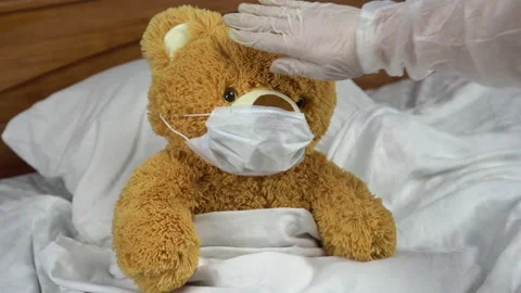 Teddy bear measure the temperature by hand. The doctor makes a measurement of Stock Footage 131016356
