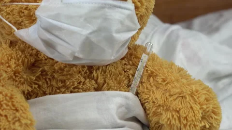 A teddy bear measures the temperature with a mercury thermometer. The doctor Stock Footage 131009301
