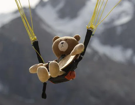 Teddy bear parachuting down in the Tien Shan mountains Foto stock