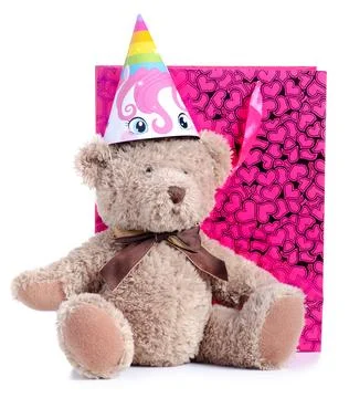 Teddy bear with party cap and pink gift bag with hearts Stock Photos
