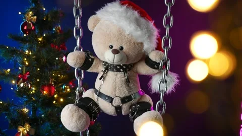 A teddy bear in a Santa Claus hat is a Christmas gift for BDSM games on the Stock Footage 165092601