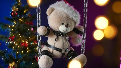 A teddy bear in a Santa Claus hat is a Christmas gift for BDSM games on the Stock Footage 165092632