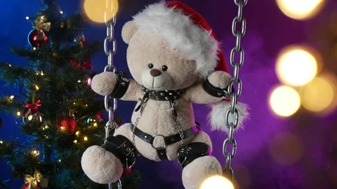 A teddy bear in a Santa Claus hat is a Christmas gift for BDSM games on the Stock Footage 165092707