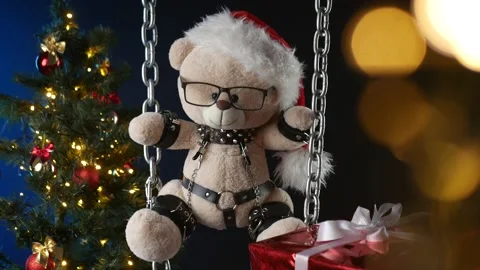 A teddy bear in a Santa Claus hat is a Christmas gift for BDSM games on the Stock Footage 165092816