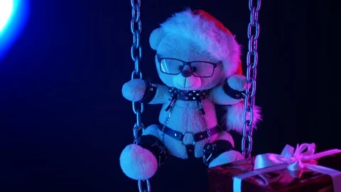 A teddy bear in a Santa Claus hat is a Christmas gift for BDSM games on chains Stock Footage 165225657