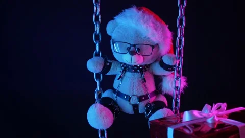 A teddy bear in a Santa Claus hat is a Christmas gift for BDSM games on chains Stock Footage 165225691