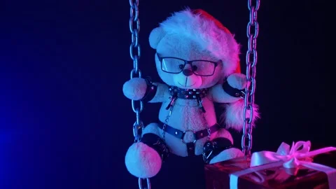 A teddy bear in a Santa Claus hat is a Christmas gift for BDSM games on chains Stock Footage 165225732