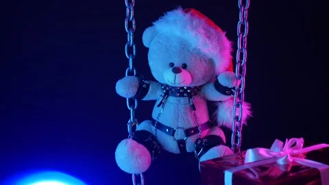A teddy bear in a Santa Claus hat is a Christmas gift for BDSM games on chains Stock Footage 165225776