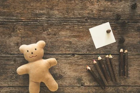 Teddy bear, sticky note and pencils Stock Photos