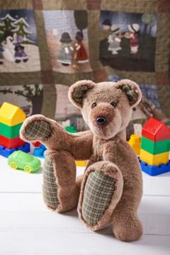 Teddy bear surrounded by blocks of children's plastic building kit Stock Photos