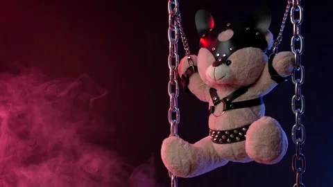Teddy bear suspended from chains in bdsm accessories in neon light in smoke Video stock 138294113