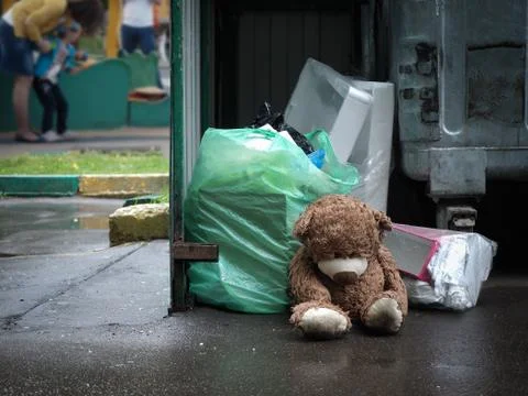 Teddy bear thrown in the trash like garbage Stock Photos