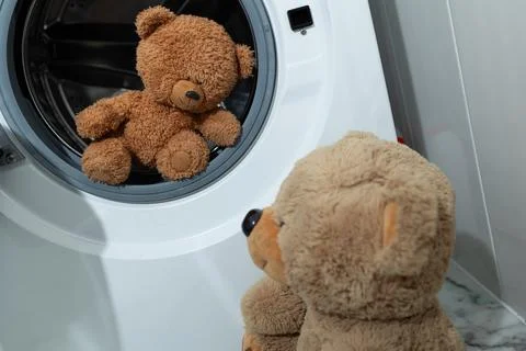 Teddy Bears Lovingly Observing a Washing Machine in a Cozy Home Scene Filled Stock Photos