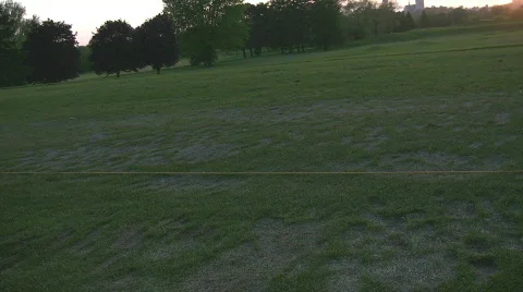 Teeing up at driving range in setting sun Stock Footage 693302