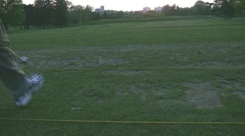 Teeing up at driving range in setting sun Stock Footage 693445