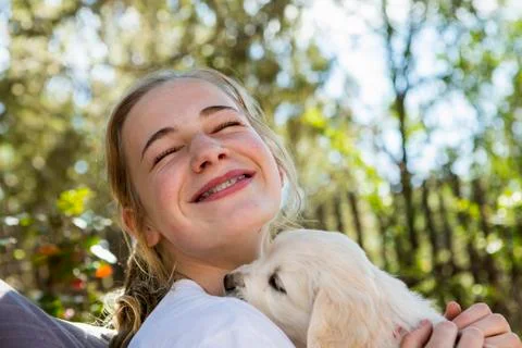 Teen age girl holding a English golden retriever puppy Stock Photos
