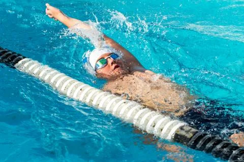 Teen backstroke swimmer in action. Stock Photos