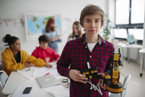 Teen boy explaining robotics project during science and technology class. Stock Photos