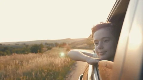 Teen boy looking out the car window. Summer trip with family Stock Footage