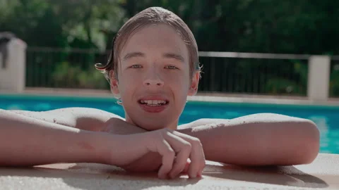 Teen Boy Puts On Clear Aligner and Smiles in Sunlit Pool Stock Footage 319879428