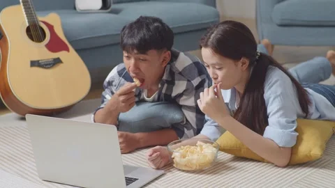 Teen Couple Using A Laptop While Lying On Carpet On The Floor At Home Stock Footage 247973722