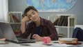 Teen dreaming of new gadget, collecting money in piggy bank, financial literacy HD Footage