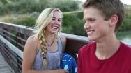 Teen Girl Flirts With Shy Boy On A Bridge, Before They Go Swimming Stock Footage