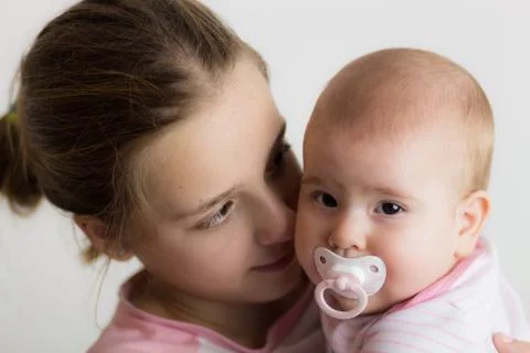 Teen Girl Holding Her Little Baby Sister Stock Photos