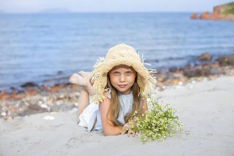Teen girl by the sea in a straw hat Stock Photos