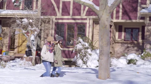 Teen Girls Enjoy A Walk Through Snow In Neighborhood Video stock 59742224