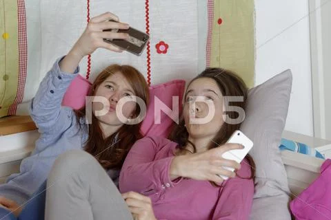 Teen girls taking selfies with their smartphones Germany Europe Stock Photos