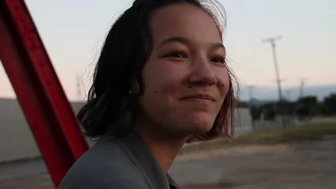 Teen grins while sitting under drive in theatre marquee Stock Footage 150393632