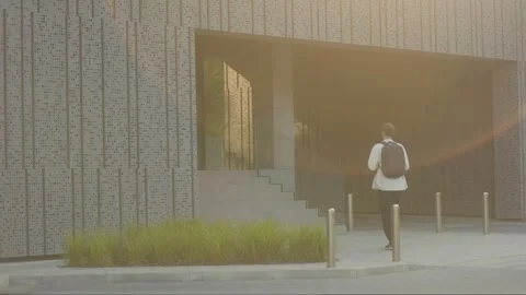 Teen guy heading up school steps, stylish morning outfit Stock Footage 311390804