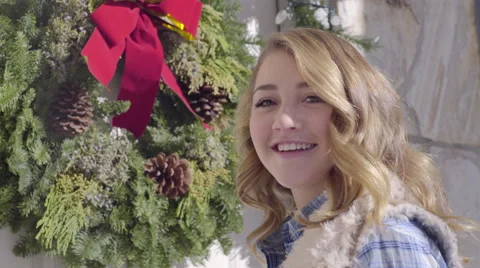 Teen Hangs A Christmas Wreath On Her Family's Front Door, She Turns And Smiles Stock Footage 59741218