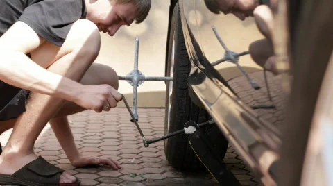 Teen raises the car jack. Stock Footage
