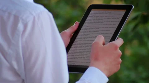 Teen Reading An E-Book In Nature Stock Footage 40625583