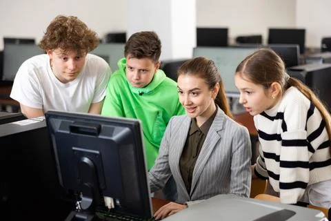Teen schoolchildren learning basics of programming with female teacher 스톡 사진