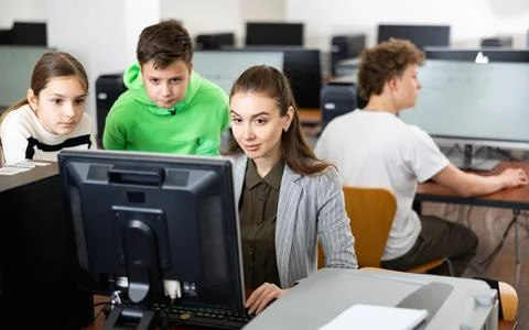 Teen schoolchildren learning basics of programming with female teacher Stock Photos