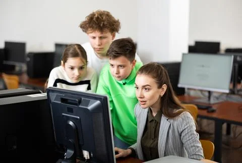 Teen schoolchildren learning basics of programming with female teacher Stock Photos