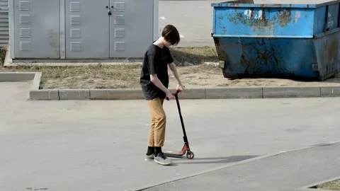 Teen on scooter performs a tricks Stock Footage 131199934